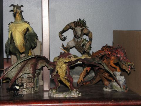 1991 Ford Bronco - Several detailed fantasy figurines, including dragons and a monster, are displayed on a wooden shelf.