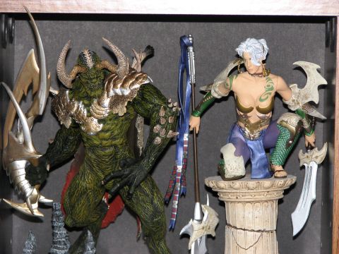 1991 Ford Bronco - A collection of detailed fantasy action figures, including a horned creature and a female warrior, are arranged for display.