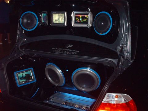 1995 Ford Probe - Custom car trunk audio system with subwoofers, screens, and blue LED lighting.
