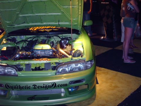 1995 Ford Probe - Customized green car with engine exposed, aftermarket modifications and text on the bumper.