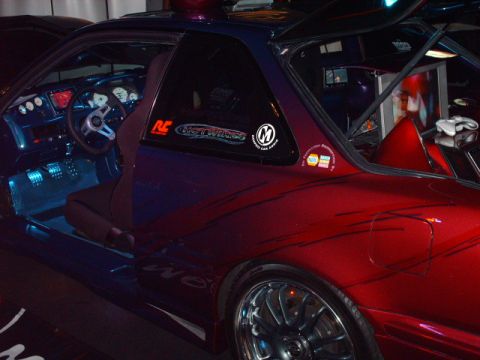 1995 Ford Probe - The interior of a modified car shows custom gauges and a steering wheel, with a two-tone paint job on the exterior.