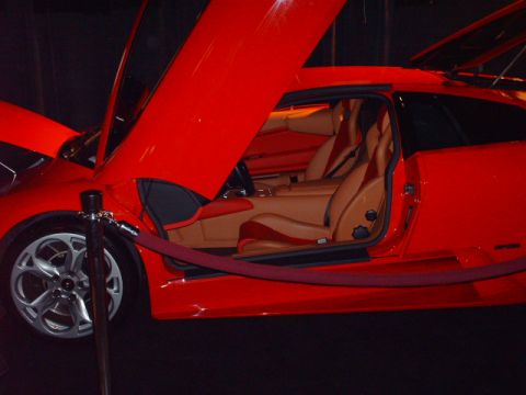 1995 Ford Probe - This red sports car features distinctive scissor doors and a tan interior, with the Supermotors.net logo visible in the lower right corner.