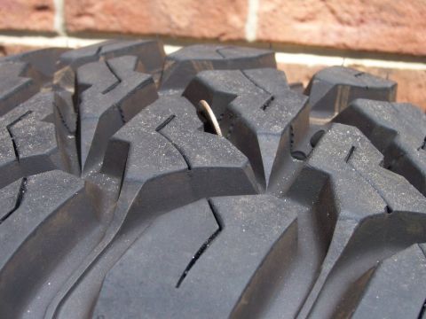 1996 Jeep Grand Cherokee - A coin is stuck in the deep tread of this off-road tire.