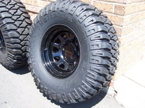 1996 Jeep Grand Cherokee - Close-up of Mickey Thompson Baja MTZ off-road tires mounted on black rims.