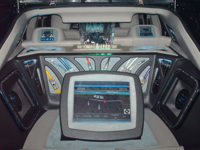 Interior view of a custom car with large screen displaying a Dodge Magnum