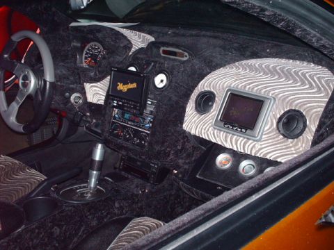 1995 Ford Probe - The dashboard and center console are covered in plush black fabric with unique wavy patterned accents.