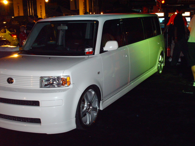 White Scion xB with custom wheels and body kit parked indoors