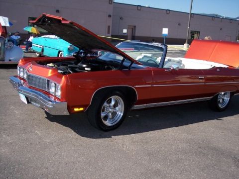 1972 Ford Ranchero - A red 1971 Chevrolet Caprice convertible is displayed with its hood open, alongside other vehicles at an outdoor event.