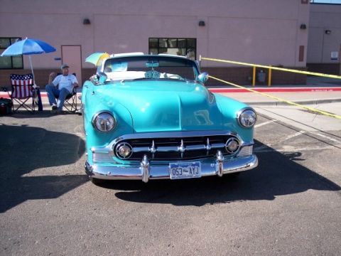 1972 Ford Ranchero - A turquoise 1953 Chevrolet Bel Air convertible is parked outside a building. A person sits in a chair nearby.
