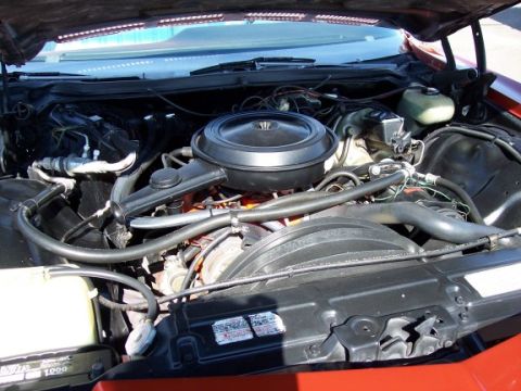 1972 Ford Ranchero - The engine bay of a red vehicle is shown, with various hoses and components visible.