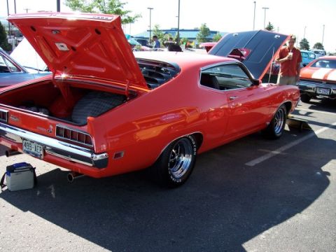 1972 Ford Ranchero - A red 1972 Ford Ranchero is displayed with its trunk and hood open at an outdoor event.