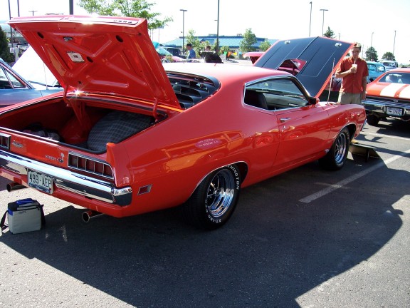 Red 1972 Ford Ranchero with open trunk and hood, showing spare tire and engine