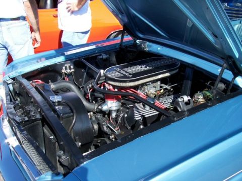 1972 Ford Ranchero - Close-up of a car's engine bay, a Cobra air filter and valve covers. Two people are visible in the background.