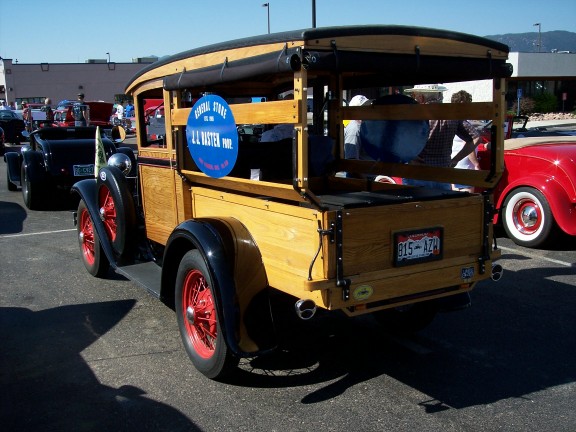 Woodie wagon with red wheels and a blue sign on the side