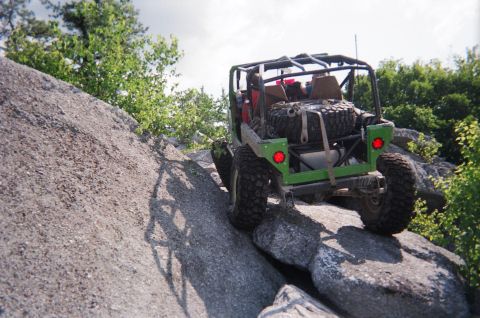 1976 GMC C/K Pickup - Off-road buggy navigates a rocky trail, demonstrating its climbing capability.