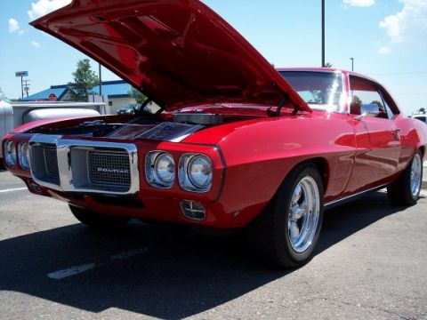 1972 Ford Ranchero - Front view of a red 1969 Pontiac Firebird, hood up, parked outdoors.