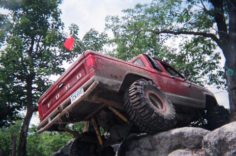 1976 GMC C/K Pickup - This red Ford pickup truck is equipped for off-road rock crawling with its large tires and lifted suspension.