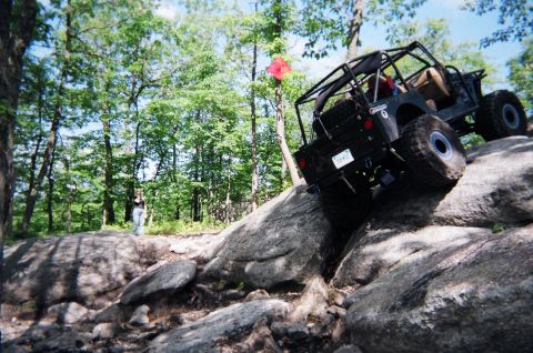 1976 GMC C/K Pickup - This off-road vehicle navigates a challenging rocky terrain, its capabilities on an uneven path.