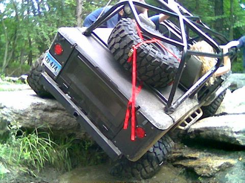 1976 GMC C/K Pickup - Off-road vehicle navigating rocky terrain with a spare tire mounted.