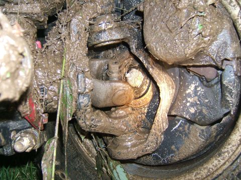 1993 Ford Bronco - This close-up shows a vehicle's suspension system completely covered in mud, obscuring most identifying details.