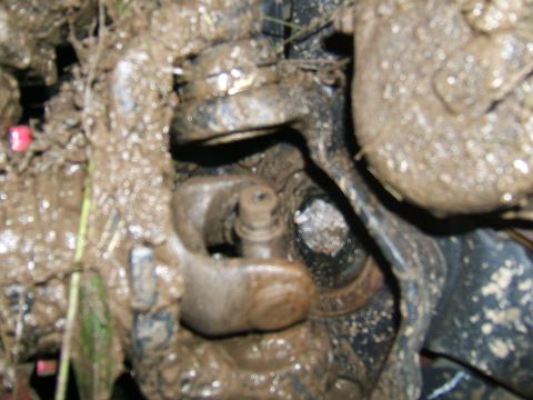 1993 Ford Bronco - Close-up of a heavily soiled drivetrain part, likely from an off-road vehicle.