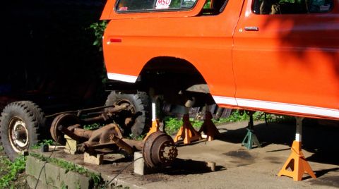 1978 Ford Bronco - Orange 1978 Ford Bronco undergoing front axle repair, supported by jack stands.