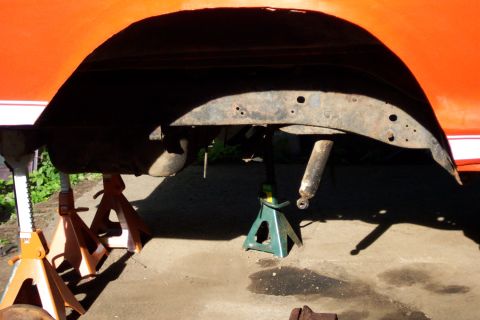 1978 Ford Bronco - Vehicle's rear wheel well and suspension components are visible while supported by jack stands.