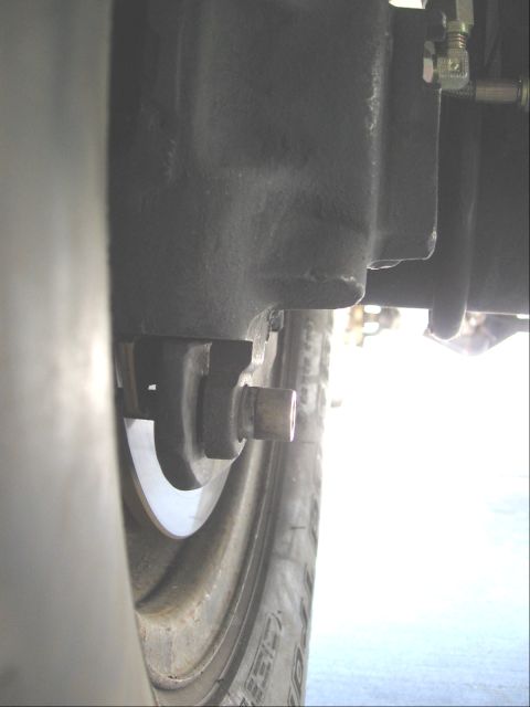 1994 Ford Bronco - A detailed view of a vehicle's braking system, focusing on the disc brake components and tire tread.