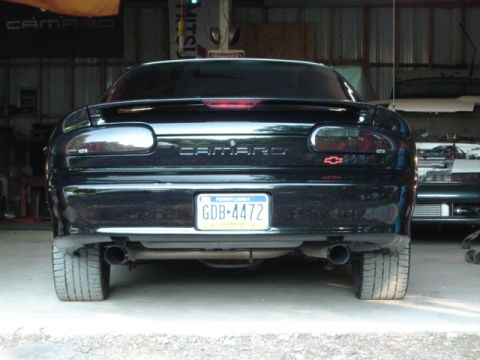 2002 Chevrolet Camaro - Rear view of a black 2002 Chevrolet Camaro, showing its distinctive taillights and dual exhaust pipes.