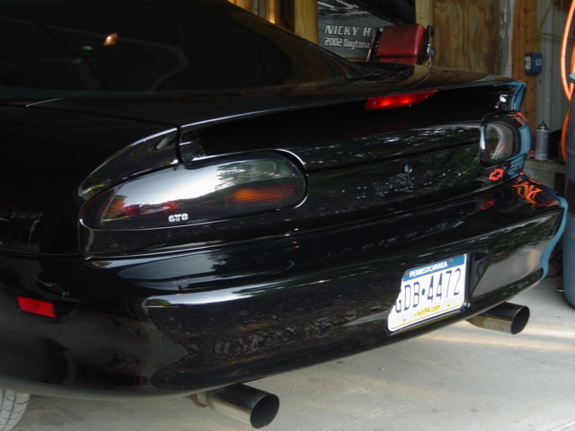 Black 2002 Chevrolet Camaro rear bumper, taillights, and dual exhaust pipes. Pennsylvania license plate GDB-4472 visible