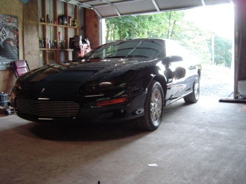 2002 Chevrolet Camaro - A black Chevrolet Camaro is parked inside a garage with the door open.