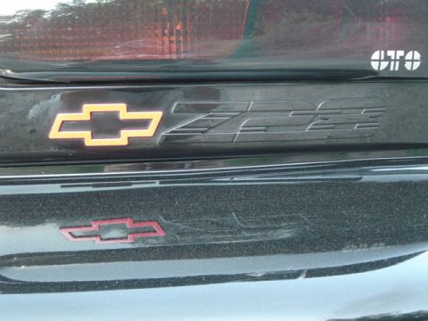 2002 Chevrolet Camaro - Close-up of Z28 emblems on a Chevrolet Camaro, with a second bowtie emblem visible.