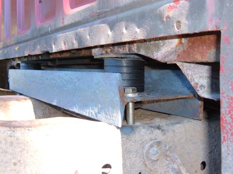 1985 Ford F-150 - Close-up view of a custom body mount rubber isolators and a metal bracket, likely for a truck modification.