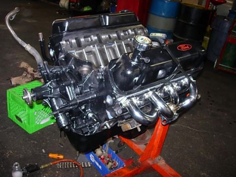 1993 Ford Bronco - A shiny Ford V8 engine is displayed on an engine stand, ready for installation or repair.