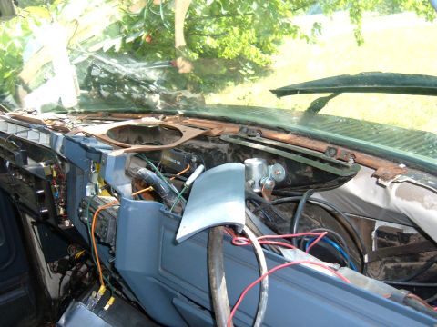 1985 Ford F-150 - The interior of a vehicle shows a disassembled dashboard with many exposed wires and components.