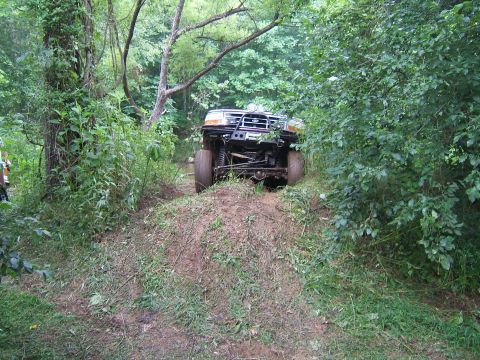 1993 Ford Bronco - This 1993 Ford Bronco is navigating a challenging off-road trail through dense woods.