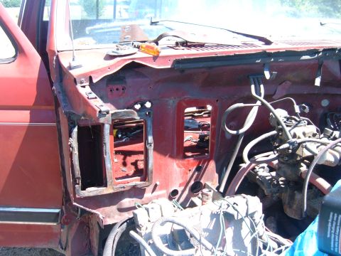 1985 Ford F-150 - The engine bay of a red truck is shown with the hood open and some parts removed.