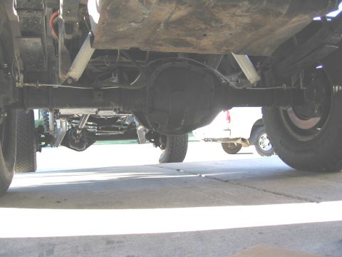 1994 Ford Bronco - Close-up of a truck's rear differential and leaf spring suspension system.