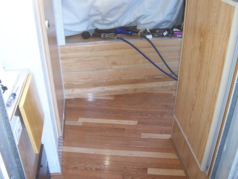 1994 Ford F-150 - The interior of a vehicle shows hardwood flooring and various tools, suggesting a work or storage area.