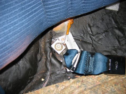 1985 Ford LTD Crown Victoria - Close-up view of a blue seatbelt buckle and carpet, showing some wear and tear.