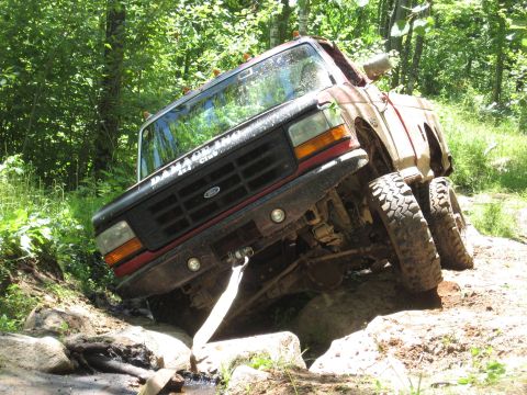 1977 Ford F-150 - This Ford truck is equipped with dual rear wheels and is shown off-roading on a rocky trail.