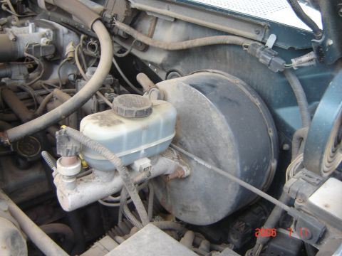 1993 Ford Bronco - Engine bay view of a 1993 Ford Bronco, focusing on the brake booster and master cylinder assembly.