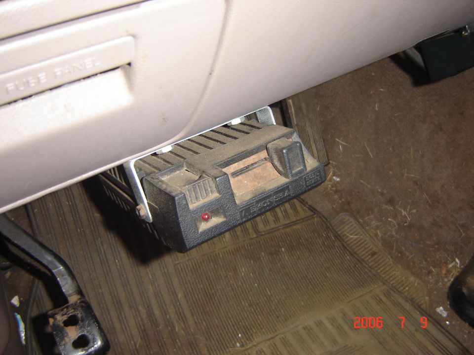 Black brake controller mounted under dashboard, with red indicator light