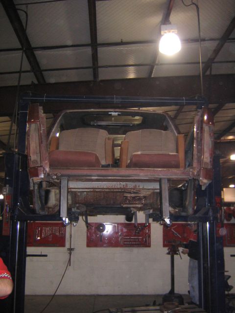 1982 Ford Bronco - Car body on a lift, showing interior and underside. The body style suggests an early 1980s vehicle.