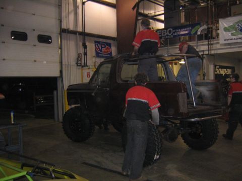 1982 Ford Bronco - Custom Ford Bronco undergoing modifications in a workshop with several people assisting.