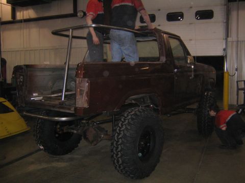 1982 Ford Bronco - A custom roll cage is being installed on a Ford Bronco in a garage setting.