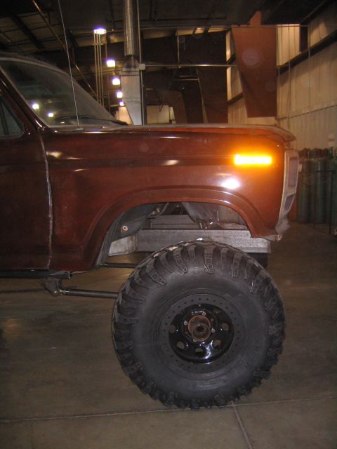 1982 Ford Bronco - Close-up of the front wheel well and fender of a lifted truck, showing its large off-road tire.