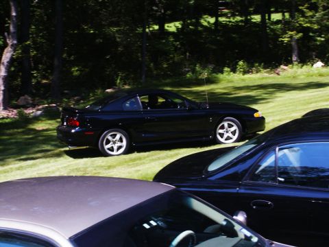 2001 Mercury Grand Marquis - A black coupe is parked on a grassy area with trees in the background.