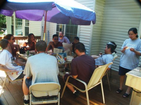 2001 Mercury Grand Marquis - A group of people enjoy a casual gathering on a wooden deck on a sunny day.
