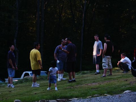 2001 Mercury Grand Marquis - A group of men and a child stand on a lawn, with trees and a partial view of a truck behind them.